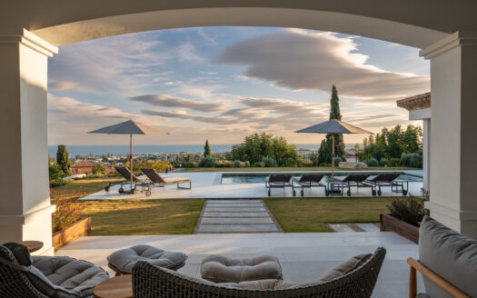 Set within the prestigious 24-hour gated community, moments from the iconic Anantara Villa Padierna Palace, this exceptional south-facing villa embodies the very best of contemporary Mediterranean luxury. Recently completed after a total high-end renovation, the residence seamlessly combines refined Andalusian architecture with cutting-edge technology and impeccable craftsmanship.
Occupying an elevated position, the villa enjoys breathtaking, uninterrupted panoramic views of the sea from every level, while its southern orientation ensures abundant natural light throughout the day. The property offers four expansive en-suite bedrooms and seven designer bathrooms, each guest suite enjoying complete privacy and luxurious finishes. Comfort is paramount, with water-based underfloor heating throughout, complemented by an advanced Airzone climate system and full smart home integration.
Designed as a private wellness and entertainment retreat, the villa features a fully equipped gym, a bespoke massage and spa room, and a versatile bar, cinema and playroom—ideal for both relaxation and social gatherings. The exterior is equally impressive. Beautifully landscaped gardens frame a heated infinity-style pool, sleek sun decks, and elegant chill-out areas, including a fire pit and chiminea. An exceptional outdoor kitchen with a premium Napoleon grill sets the scene for unforgettable al-fresco dining against a stunning sea backdrop.
Additional features include:
– Mobalco designer kitchen with Gaggenau appliances
– High-quality Roman carpentry and Cortizo aluminium windows
– Electric blinds and insect screens throughout
– Italian Natuzzi sofas and Dedon outdoor furniture
– LG televisions in every room
– Water descaling system
– Verisure alarm system
– Integrated garage for two vehicles with electric car charger
This is a rare opportunity to acquire a turnkey luxury villa in one of Benahavís’ most sought-after gated communities—offering privacy, security, world-class finishes, and an unrivalled coastal lifestyle.