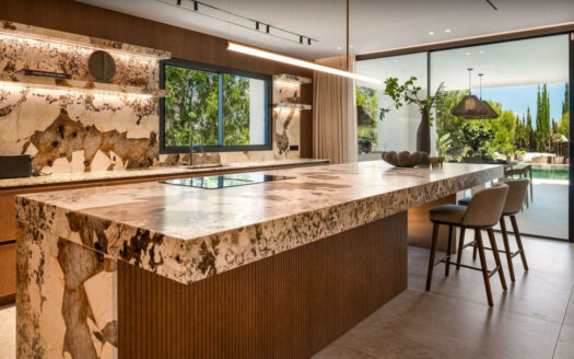 Eingebettet in die prestigeträchtige Wohnanlage El Herrojo in La Quinta vereint diese außergewöhnliche Villa mit sechs Schlafzimmern auf harmonische Weise den klassischen andalusischen Stil mit moderner, zeitgemäßer Eleganz. Kürzlich mit Materialien höchster Qualität vollständig renoviert, bietet die Immobilie eine perfekte Kombination aus Komfort, Stil und zeitloser Raffinesse.
Die Villa erstreckt sich über drei sorgfältig gestaltete Ebenen und wird komplett möbliert sowie bezugsfertig angeboten. Im Hauptgeschoss erwarten Sie großzügige, offen gestaltete Wohnbereiche mit viel Tageslicht sowie eine hochmoderne Küche mit erstklassigen Elektrogeräten. Ein stilvolles Gästezimmer und mehrere einladende Innen- und Außenbereiche schaffen ideale Voraussetzungen für entspanntes Familienleben und repräsentative Anlässe.
Im Obergeschoss befinden sich drei großzügige Schlafzimmer, jeweils mit eigener privater Terrasse und schönem Blick auf die umliegende Landschaft. Die beeindruckende Master-Suite ist ein wahres Refugium und verfügt über einen eigenen Loungebereich, einen maßgefertigten begehbaren Kleiderschrank sowie ein luxuriöses en-suite Badezimmer im Spa-Stil.
Das Untergeschoss setzt neue Maßstäbe in Sachen Wohlbefinden und Freizeitgestaltung: Hier finden sich ein privates Fitnessstudio, ein exklusiver Spa-Bereich mit Sauna sowie zwei weitere Gäste-Suiten. Im Gegensatz zu vielen Untergeschossen überzeugt diese Ebene durch viel natürliches Licht und eine warme, einladende Atmosphäre.
Umgeben von der beeindruckenden Berglandschaft Marbellas bietet diese Villa ein Höchstmaß an Privatsphäre und Ruhe, während erstklassige Golfplätze, internationale Schulen und die berühmte Goldene Meile nur wenige Minuten entfernt liegen. Eine seltene Gelegenheit, eine einzigartige Immobilie in einer der exklusivsten Wohnlagen Marbellas zu erwerben.