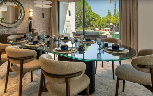 Eingebettet in die prestigeträchtige Wohnanlage El Herrojo in La Quinta vereint diese außergewöhnliche Villa mit sechs Schlafzimmern auf harmonische Weise den klassischen andalusischen Stil mit moderner, zeitgemäßer Eleganz. Kürzlich mit Materialien höchster Qualität vollständig renoviert, bietet die Immobilie eine perfekte Kombination aus Komfort, Stil und zeitloser Raffinesse.
Die Villa erstreckt sich über drei sorgfältig gestaltete Ebenen und wird komplett möbliert sowie bezugsfertig angeboten. Im Hauptgeschoss erwarten Sie großzügige, offen gestaltete Wohnbereiche mit viel Tageslicht sowie eine hochmoderne Küche mit erstklassigen Elektrogeräten. Ein stilvolles Gästezimmer und mehrere einladende Innen- und Außenbereiche schaffen ideale Voraussetzungen für entspanntes Familienleben und repräsentative Anlässe.
Im Obergeschoss befinden sich drei großzügige Schlafzimmer, jeweils mit eigener privater Terrasse und schönem Blick auf die umliegende Landschaft. Die beeindruckende Master-Suite ist ein wahres Refugium und verfügt über einen eigenen Loungebereich, einen maßgefertigten begehbaren Kleiderschrank sowie ein luxuriöses en-suite Badezimmer im Spa-Stil.
Das Untergeschoss setzt neue Maßstäbe in Sachen Wohlbefinden und Freizeitgestaltung: Hier finden sich ein privates Fitnessstudio, ein exklusiver Spa-Bereich mit Sauna sowie zwei weitere Gäste-Suiten. Im Gegensatz zu vielen Untergeschossen überzeugt diese Ebene durch viel natürliches Licht und eine warme, einladende Atmosphäre.
Umgeben von der beeindruckenden Berglandschaft Marbellas bietet diese Villa ein Höchstmaß an Privatsphäre und Ruhe, während erstklassige Golfplätze, internationale Schulen und die berühmte Goldene Meile nur wenige Minuten entfernt liegen. Eine seltene Gelegenheit, eine einzigartige Immobilie in einer der exklusivsten Wohnlagen Marbellas zu erwerben.